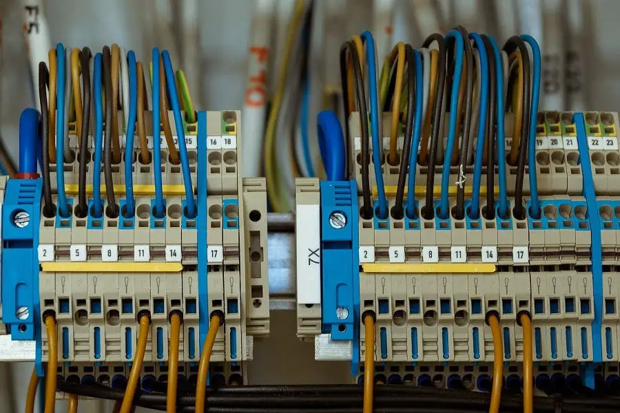 Image of a row of feed-through terminals to which various electrical cables are connected